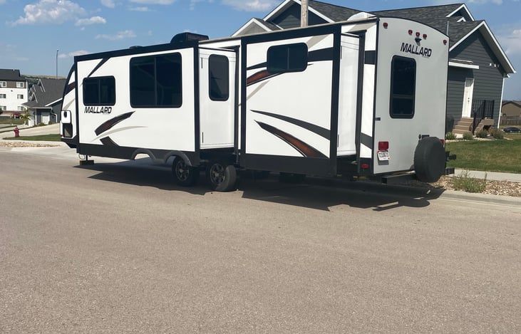 Drivers side shows the 2 slides. One for the living and dining areas. The back one opens up the back bedroom with extra tv and DVD player.