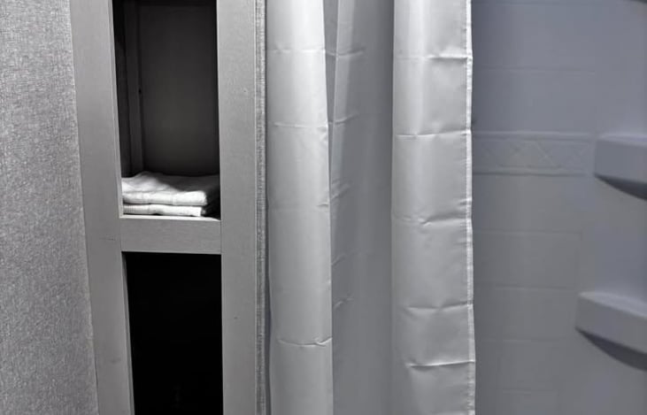 A clean, well‑stocked bathroom nook with fresh towels and essentials neatly organized for a comfortable stay.