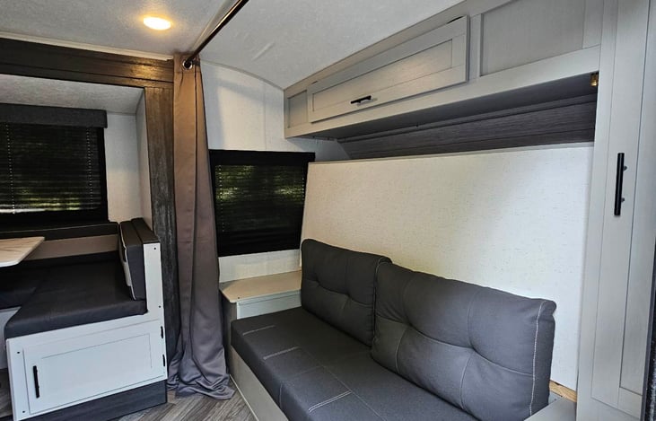 Master Bed stored, couch exposed. Tall cabinet does have a hanging rod (no hangers included). View from the front door.