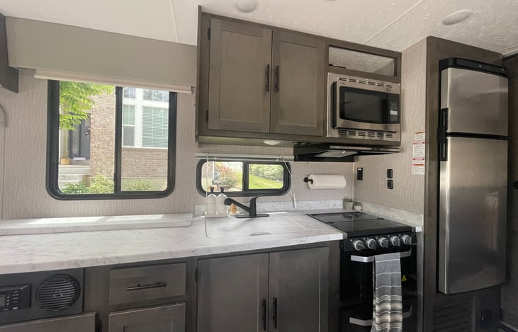 Indoor kitchen. Fridge, freezer, microwave, gas stove, & oven.