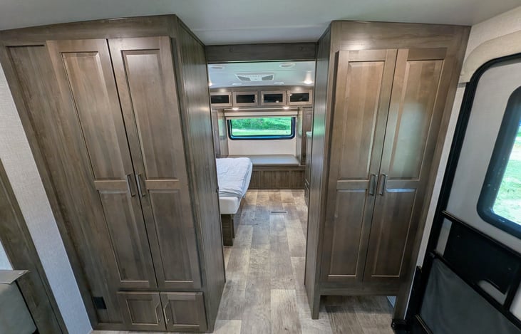 Private front bedroom features a walk-around Queen bed, TV, ample wardrobe storage, and a cozy built-in window seat nook—perfect for relaxing with a book! Full of natural light from 6 windows.
