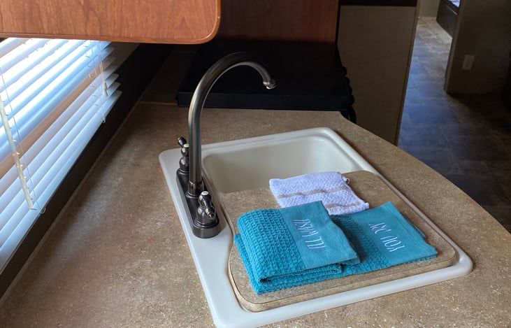 Fully stocked kitchen plates cups towels silverware pots pans utensils