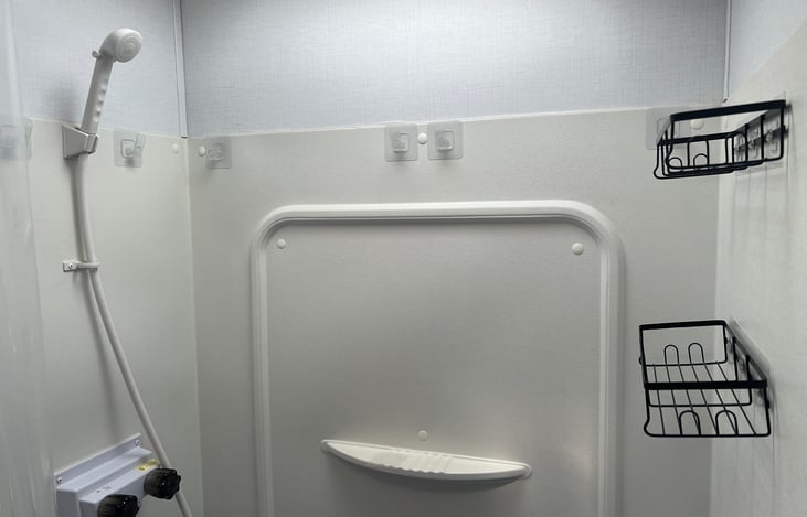 The shower comes outfitted with hooks for towels or bathing suits and baskets for your soaps or shampoos.