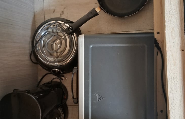 Under the left bench you will find you coffee maker! Also an extra stove top and a microwave oven. And pots and pans.