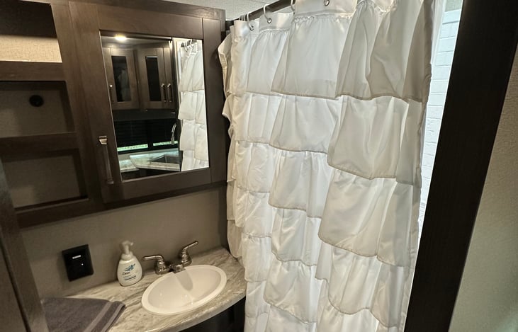 We added a shower curtain because we liked the way it looked better, however there is a slide barrier that can be used if preferred. The shower curtain can be easily taken off.