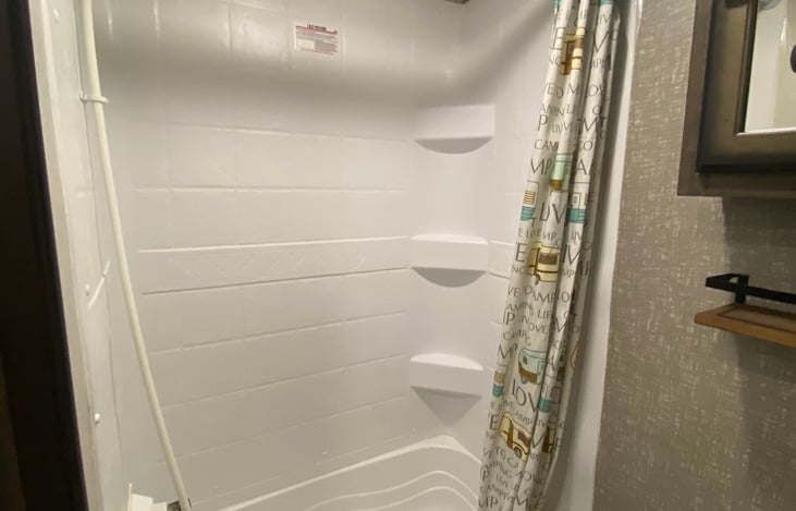 A small tub is at the bottom of the shower, great for baths for littles.