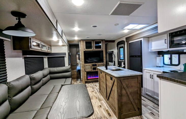 Kitchen with island and living/dining area with entertainment center and fireplace