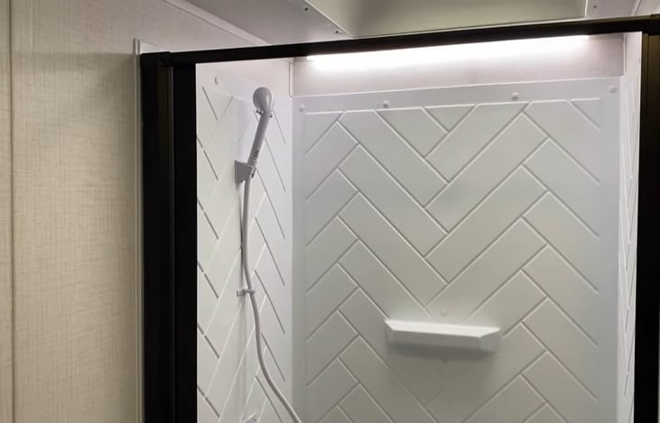 Bathroom with toilet, shower,  and sink. Includes RV safe toilet paper and Liquified tank treatment