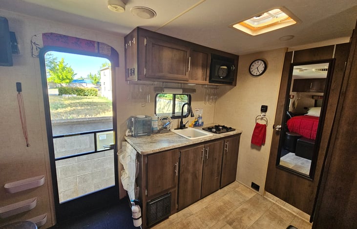 Spacious kitchen counter space with 2 gas burners and kitchen essentials included..... plates, plastic cups and stemware, utensils, cookware, storage containers, etc. Starter paper towels provided.