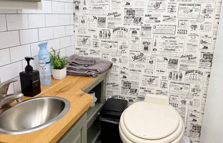 Clean private RV bathroom with sink, toilet & storage – convenient for camping and festival trips