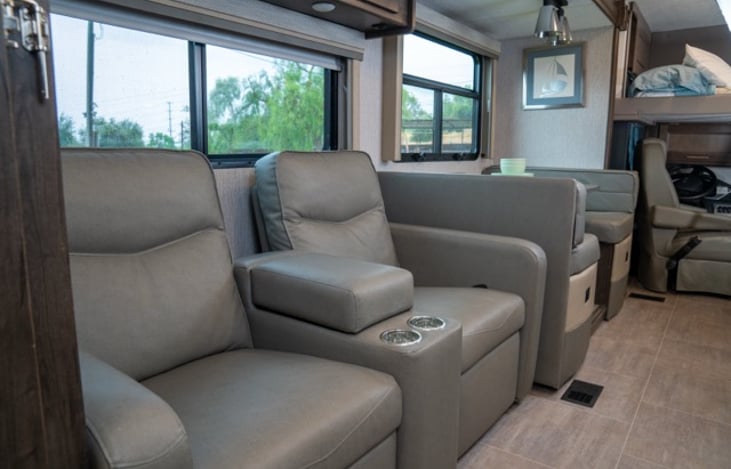 reclining theatre style sofas with built in cup holders across from the fireplace and entertainment center for relaxing and unwinding anytime.