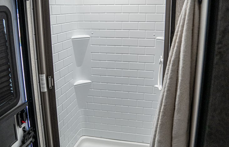 spacious shower with room for your toiletries and a sliding shower door just like at home.