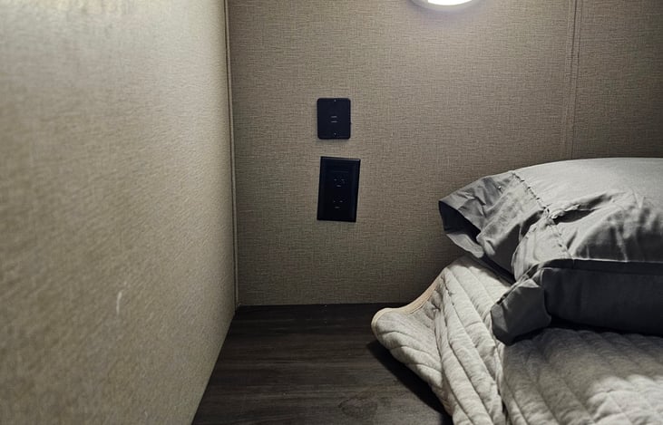outlets and light near full bed