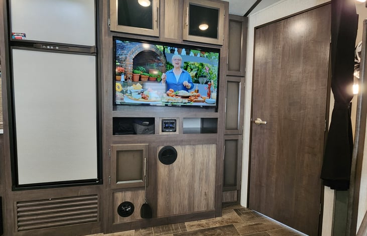 Large Tv with bathroom to the right, with its own entry and exit to outside.