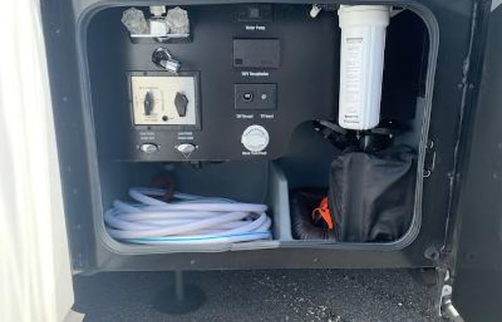 Water bay. fresh water, holding tanks dump controls, cable hookup, rinse hose, & water filter.