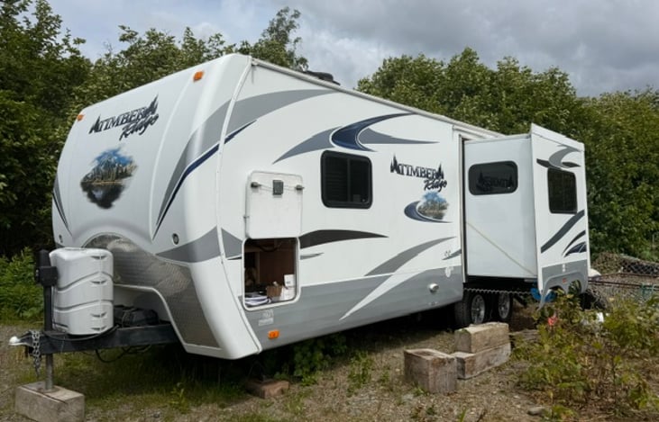 Exterior view with slide out and extra storage area open