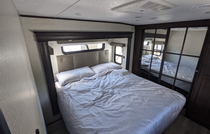 Master bed King size  behind mirrors is a walk-in closet with above storage and hanging rod. Under the king bed is storage also.