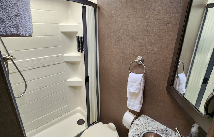 Full bath previously stocked with shampoo, conditioner and body wash dispensers