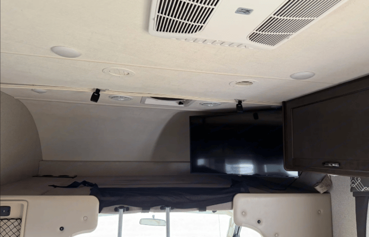 Overhead bunk, with the main area TV and storage cabinet.