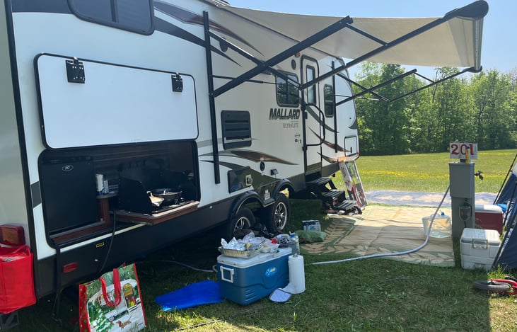 Awning, outdoor fridge, stovetop cooker and sink.