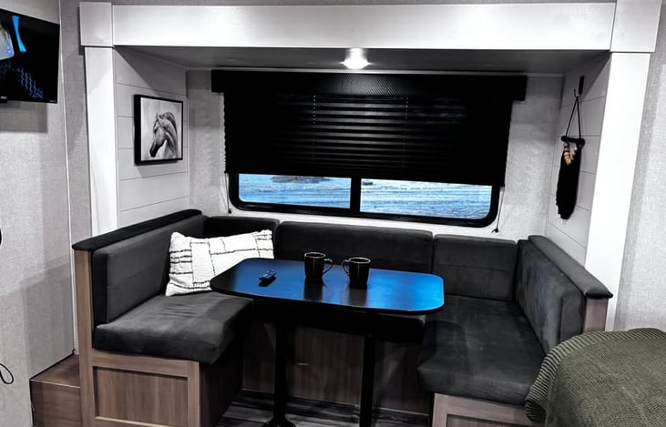 A stylish U‑shaped dinette with a scenic window view, perfect for meals, lounging, and enjoying the surroundings during your stay.