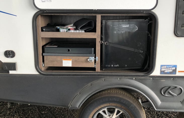 Two burner pull out propane camp stove & fridge.  Stove ties into camper's propane delivery system.
