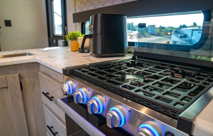 three burner stove with hooded vent.  stove self lights and knobs light up.  oven below also has an interior light for easy monitoring of your dishes.