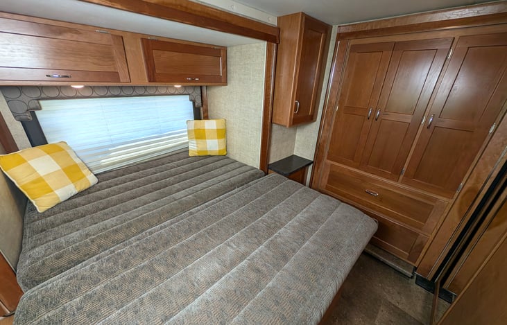Cozy queen bed in the back with a slide-out closet and plenty of storage.