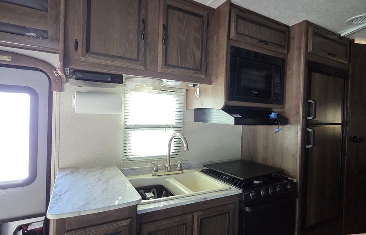 Kitchen. Dual sink, 3-burner stove with oven and a microwave.