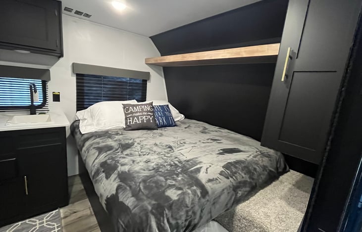 Queen bed with shelf and storage closet. Additional large storage compartment located under bed.