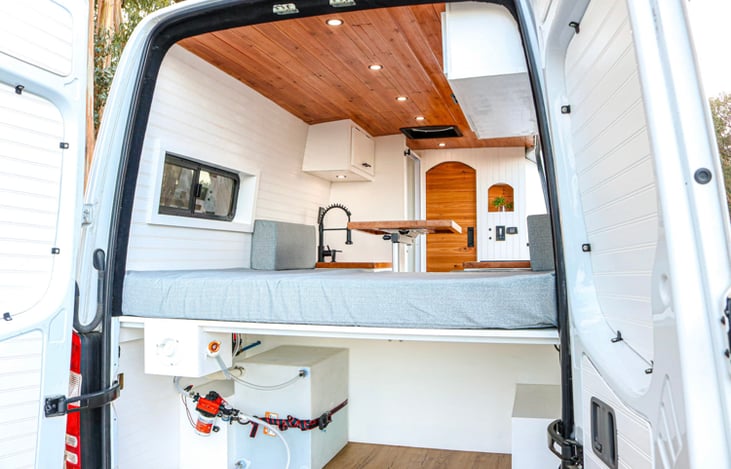 The van is extremely open with nothing obstructing view to the outdoors. Back window covers included. Storage area, 26 gallon water system under bed.