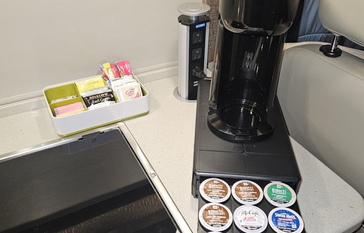 Beverage station with K-Cup coffee maker, pods, tea, and sweeteners. Your beverage options are customizable.