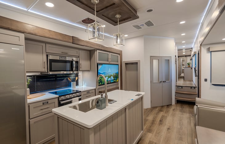 Main living area featuring a full-size refrigerator, a versatile dining space that converts into an additional sleeping area, and two luxurious recliners perfectly positioned by a cozy fireplace.