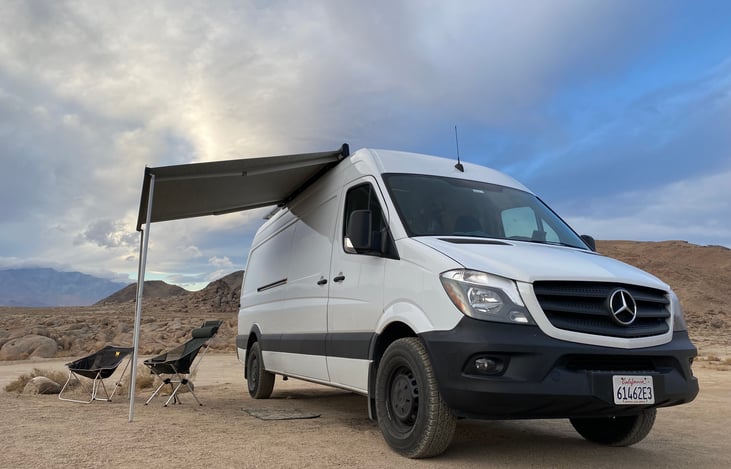 The manual awning is easy to crank in and out. Provides shelter from sun/rain. 2 folding chairs included.