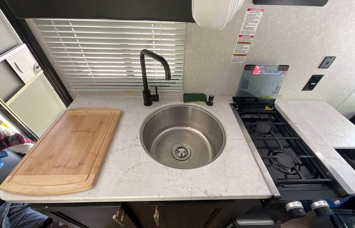 Your cooking and cleaning area. Under the sink is the toilet paper, paper towel and eating utensils.