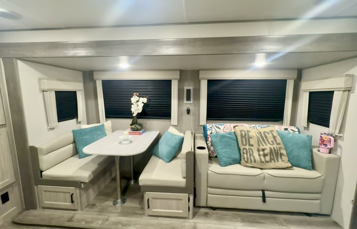 Coming in the  door you’re greeted by the cozy  couch (pull out that sleeps 2) and the dinette (also breaks down into a bed that sleeps 2).