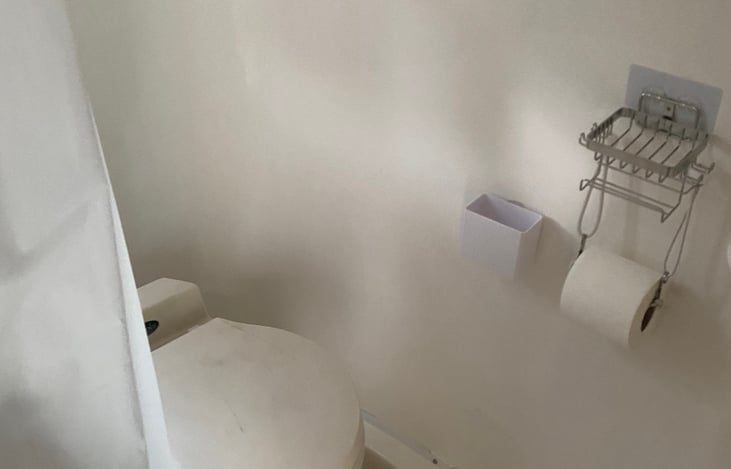 Casita wet bathroom view with small hand wash sink, toilet, and convertible shower. Towels, soap, and toilet paper included.