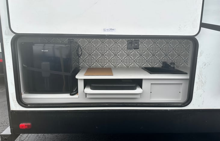 Outdoor kitchen w/ sink, mini fridge, and small stove/grill