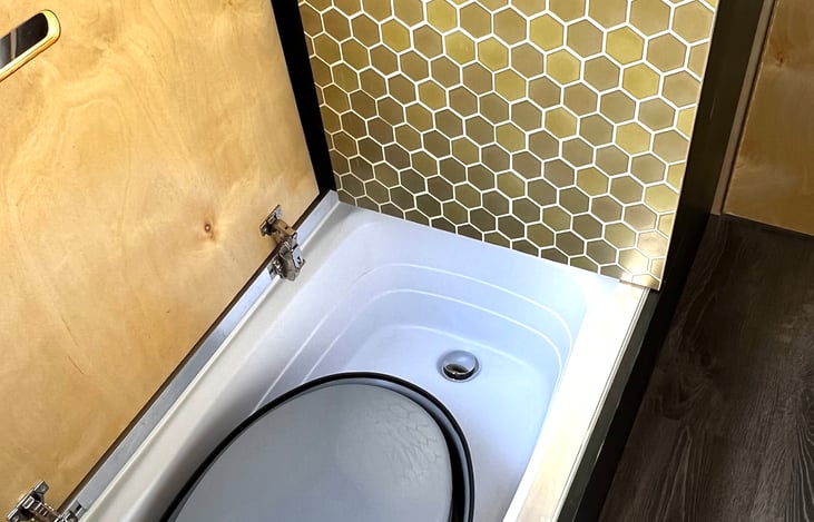 Folded toilet is stored in bathtub. Toilet is collapsible. Once you are ready to drive, you can store it in bathtub to save the space.