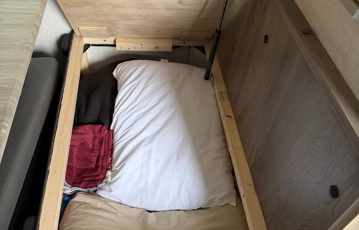 Extra pillows and blankets under the table seat