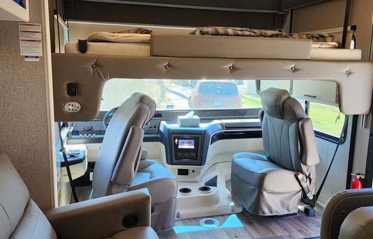 Plenty of space and comfortable captain chairs in the driving area. Driver chair is power positional. Steering wheel raised up/down. RV also has cruise control for the open highway driving.