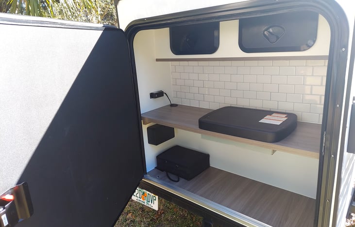 Rear galley, propane stove, outlets and overhead storage for camp kitchen