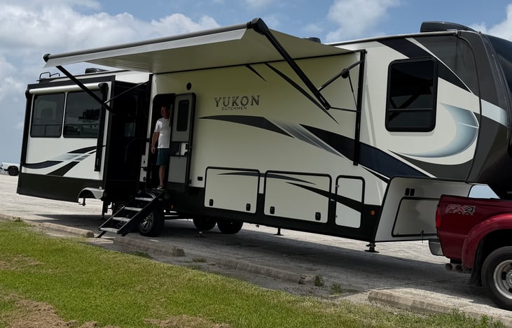 Premium Outdoor Living: Over 42 feet of high-gloss fiberglass elegance featuring dual electric adjustable power awnings with built-in LED lighting.