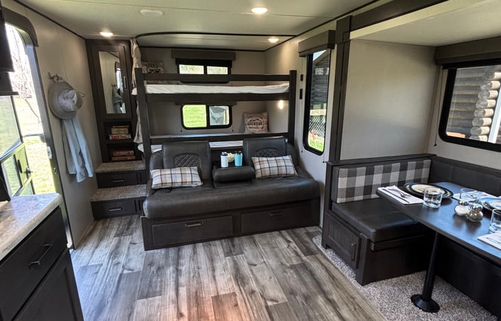 Comfy couch with fold down arm rest and cup holders, that also turns into a bed and creates a nice area for the kids with the bunk beds right behind.
More storage underneath!