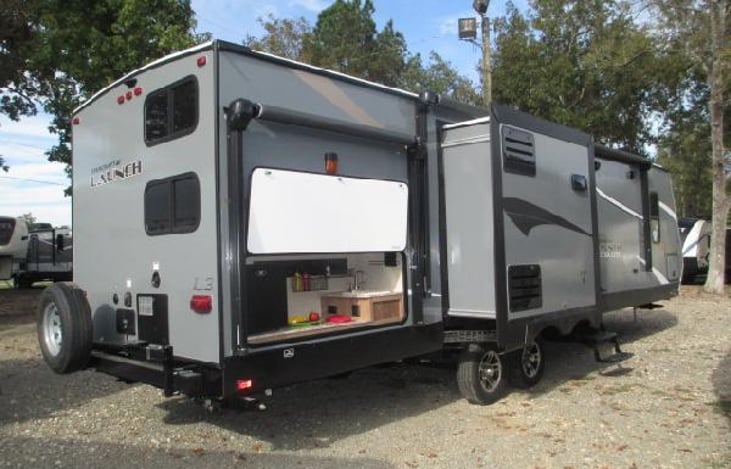 Outside Kitchen area with refrigerator, sink and grill.