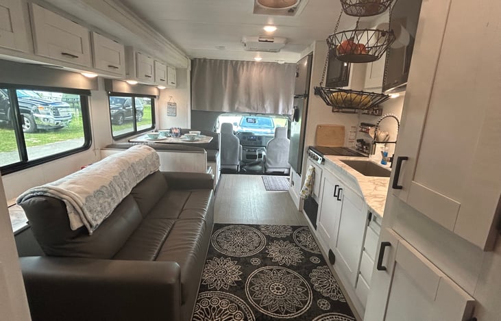 As you walk in, the kitchen is on the left and the dinette is on the right. Black bedroom accordion door is at the back left and bathroom door (with over-door towel rack) is on the right.
