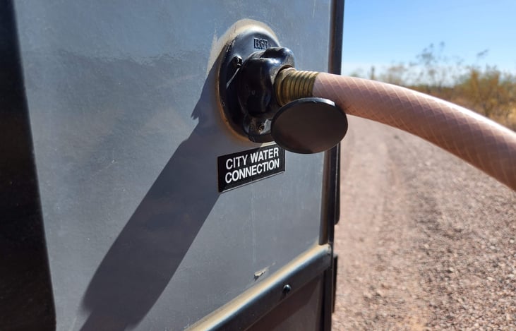Fresh water city hose connection at the rear of the trailer (non-camp side).