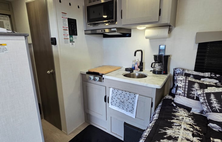 Kitchen galley; dishes, silverware, pots/Pans, knifes, cooking utensils, can opener, scissors, predator deterrent, paper towels, Disinfectant wipes, clothesline, dish drying rack, seasonings.