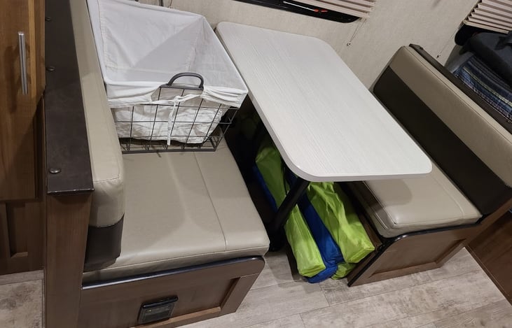 Dinette converts to bed for sleeping.  Wire basket sits on top of Blackstone cabinet for dirty linens and towels, when not in tow.