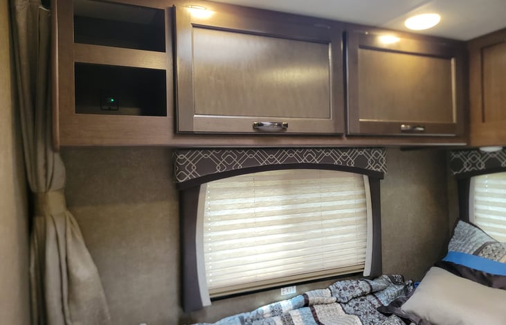 The bed area has USB charging ports, a 12v socket-3 overhead storage areas for clothes, bedtime stories, phones, etc.